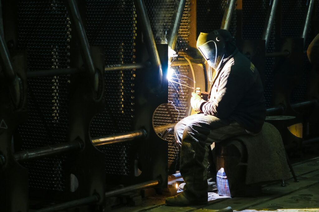 A professional welder working in an industrial factory setting, ensuring quality metalwork.